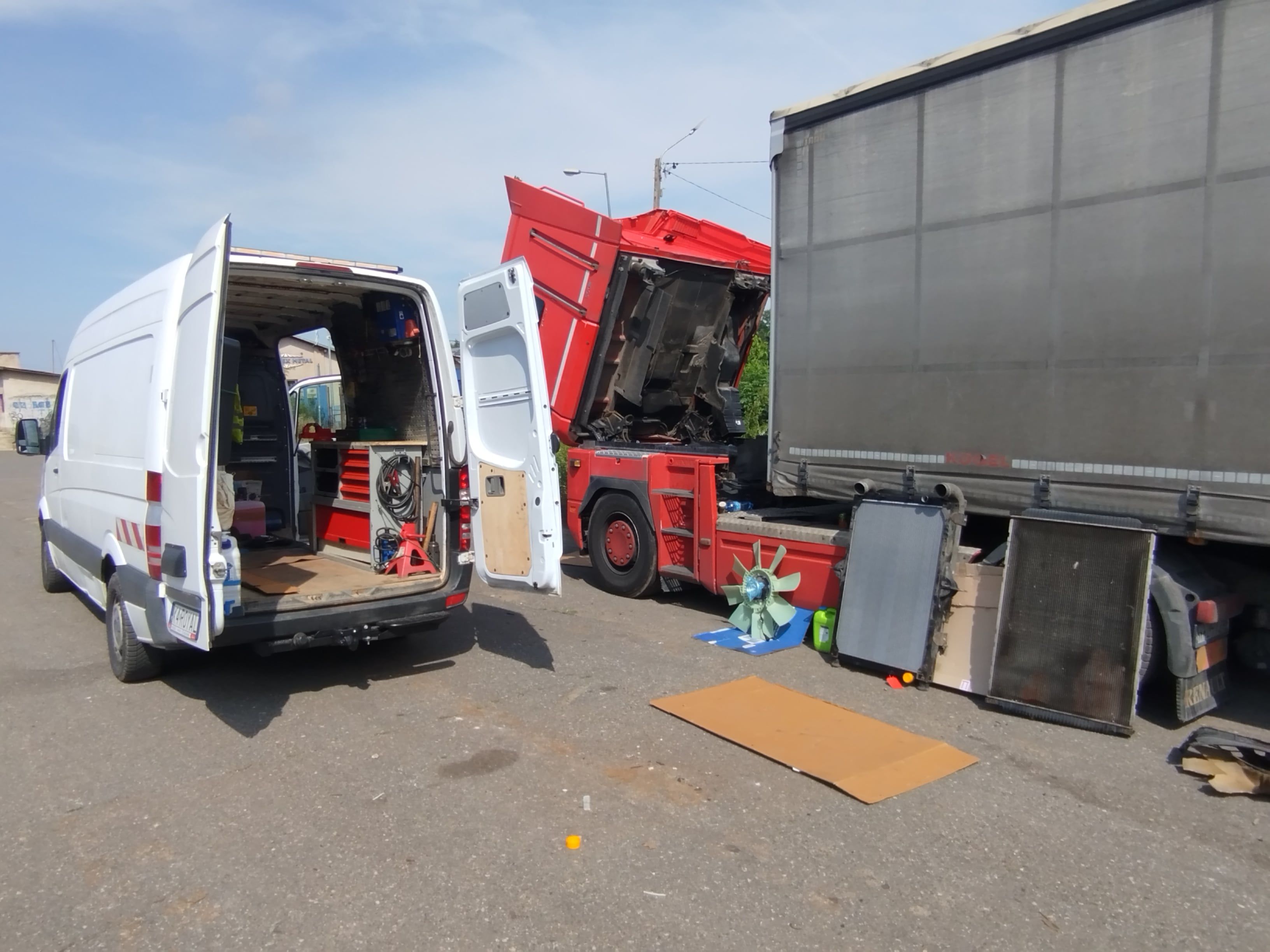 Biały bus mobilnego serwisu ciężarówek podczas interwencji i naprawy uszkodzonego tira na poboczu drogi w słoneczny dzień