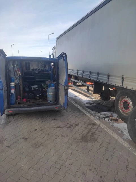 Niebieski wóz serwisowy z otwartymi drzwiami pokazujący narzędzia i sprzęt.